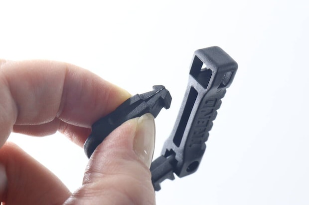 女性の指がキーホルダー上部のカラビナのパーツを引き抜いて開いている様子