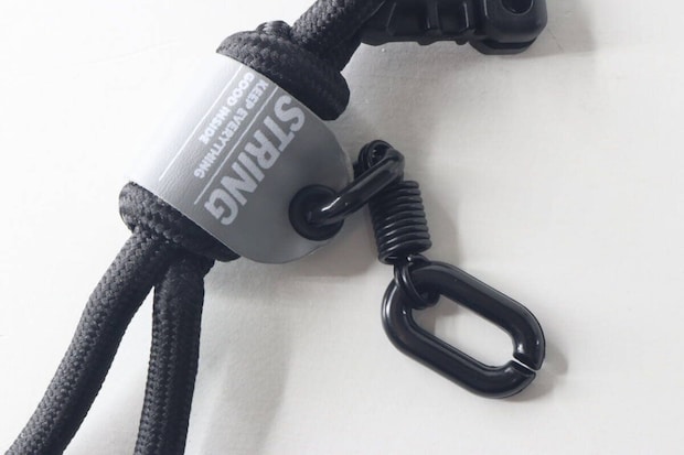 キーホルダー中央の「STRING」ロゴタグと下部のカラビナのアップ