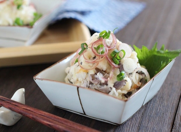 白い器に盛られたしば漬けとちくわのポテトサラダにみょうがと万能ねぎが添えられている 白い器に盛られたしば漬けとちくわのポテトサラダにみょうがと万能ねぎが添えられている