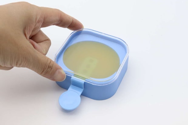アイスキャンディーメーカーに透明な蓋を閉めている手元