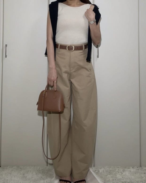ベージュトップスとパンツにネイビーのカーディガンを肩掛けしたOKコーデ