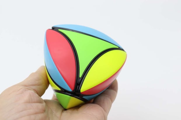 手のひらに乗せられた赤青緑黄色のカラフルな立体パズル 手のひらに乗せられた赤青緑黄色のカラフルな立体パズル