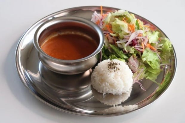 ステンレス皿にカレーポット、ライス、サラダが盛り付けられた様子 ステンレス皿にカレーポット、ライス、サラダが盛り付けられた様子