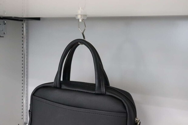 ロッカーの天井に吊るした磁石フックに黒いカバンを掛けている ロッカーの天井に吊るした磁石フックに黒いカバンを掛けている