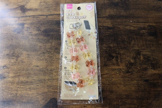 木目のテーブルに置かれたスマホリストストラップのパッケージ