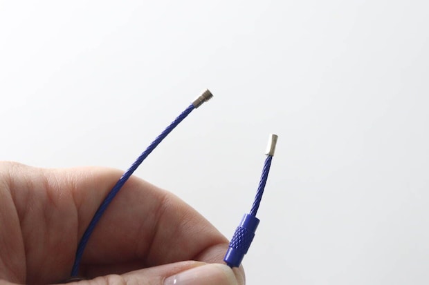 モーテルキーホルダーのネジ式ワイヤーを指で開いている様子 モーテルキーホルダーのネジ式ワイヤーを指で開いている様子
