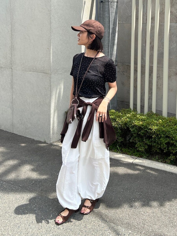 ドット柄Tシャツと腰巻きカーデの女性