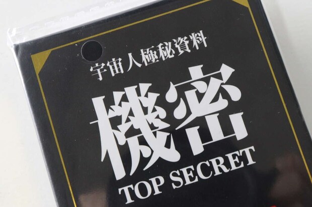 パッケージに入った「宇宙人極秘資料 機密 TOP SECRET」と書かれたブック型メモ帳のアップ パッケージに入った「宇宙人極秘資料 機密 TOP SECRET」と書かれたブック型メモ帳のアップ