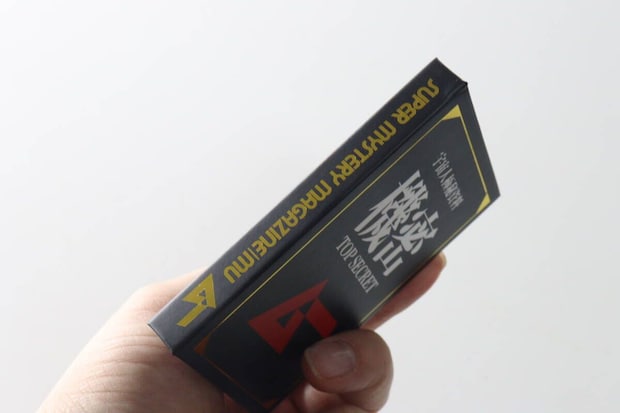 手に持ったブック型メモ帳の背表紙。SUPER MYSTERY MAGAZINE MUの文字 手に持ったブック型メモ帳の背表紙。SUPER MYSTERY MAGAZINE MUの文字