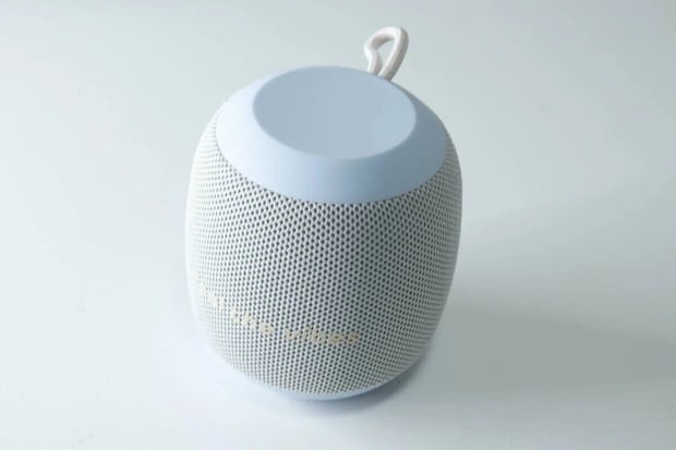 水色と白の丸いBluetoothスピーカーが白背景に置かれている