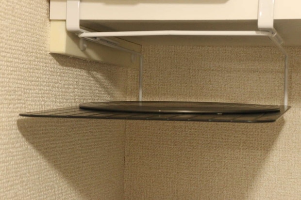 吊り戸棚ラックに黒い丸いまな板を収納している様子 吊り戸棚ラックに黒い丸いまな板を収納している様子