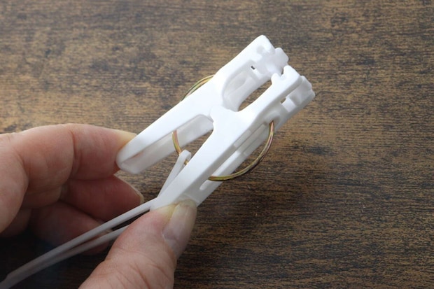 指で白い洗濯ピンチの先端部分を掴み構造を見せている