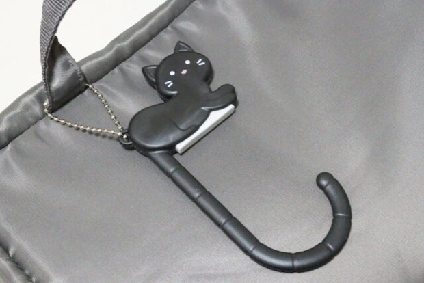 黒猫のバッグフックがグレーのバッグに付いている