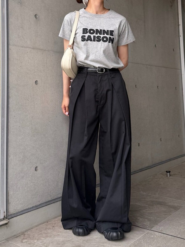 グレーのロゴTと黒のワイドパンツを着用し、ウエストマークした女性 グレーのロゴTと黒のワイドパンツを着用し、ウエストマークした女性