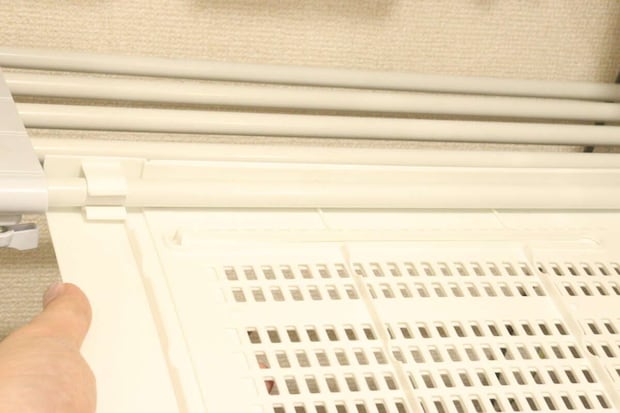 つっぱり棒用棚を、つっぱり棒に差し込んで設置する様子 つっぱり棒用棚を、つっぱり棒に差し込んで設置する様子