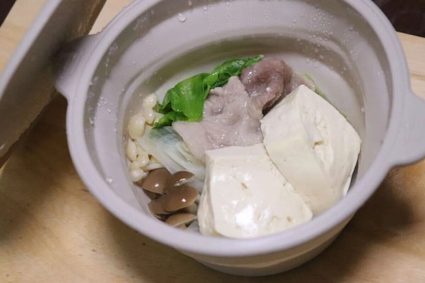 シリコーン小鍋に豚肉、豆腐、きのこ、葉物野菜が入れられている シリコーン小鍋に豚肉、豆腐、きのこ、葉物野菜が入れられている