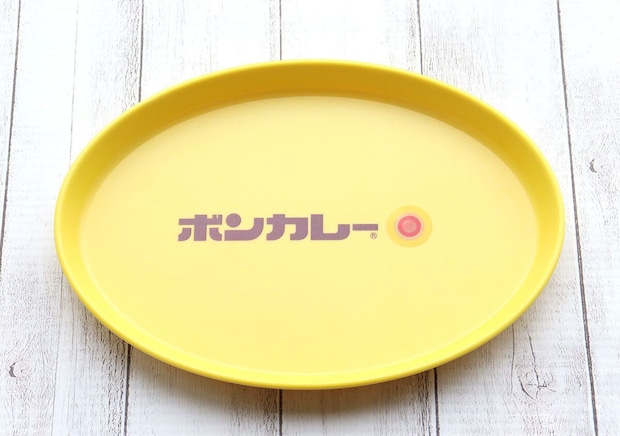 黄色いボンカレー皿が置かれているアップ。中央にボンカレーのロゴ