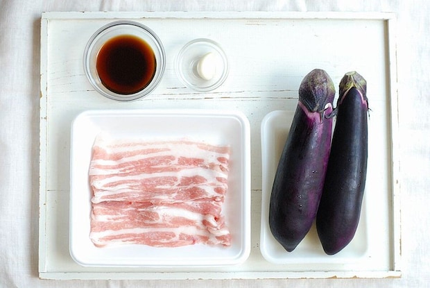 白い木製の板の上に並べられた、なす、豚バラ肉、ポン酢、にんにく 白い木製の板の上に並べられた、なす、豚バラ肉、ポン酢、にんにく