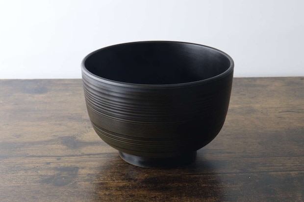 木目のテーブルに置かれたこげ茶色の汁椀 木目のテーブルに置かれたこげ茶色の汁椀