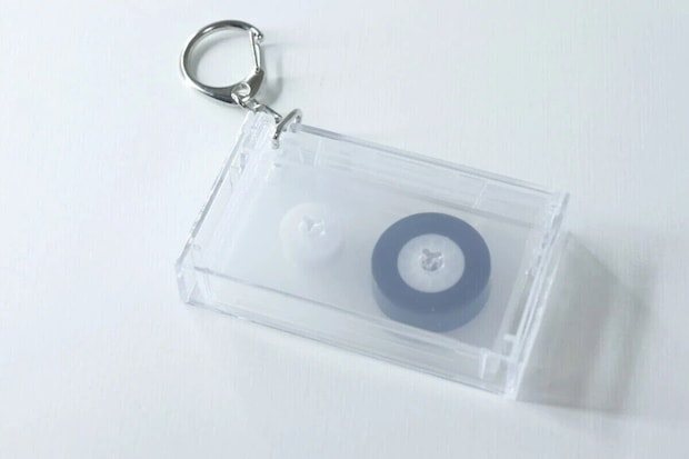 透明なカセットテープ型キーホルダー。中に黒と白のリールが見える 透明なカセットテープ型キーホルダー。中に黒と白のリールが見える