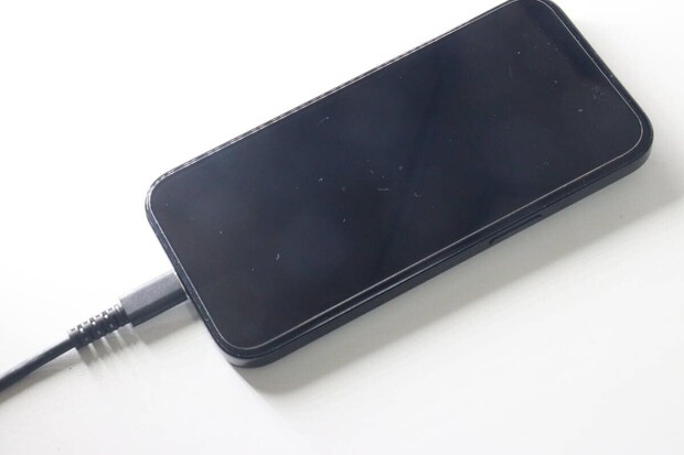 黒いスマートフォンにUSB Type-Cケーブルが接続されている 黒いスマートフォンにUSB Type-Cケーブルが接続されている