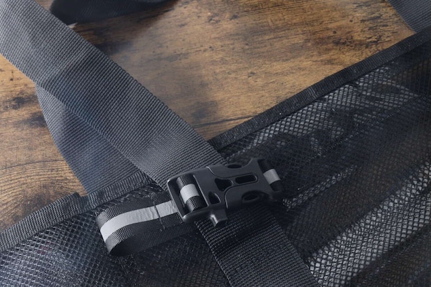 黒いバッグのストラップ部分に装着された反射材バックル 黒いバッグのストラップ部分に装着された反射材バックル
