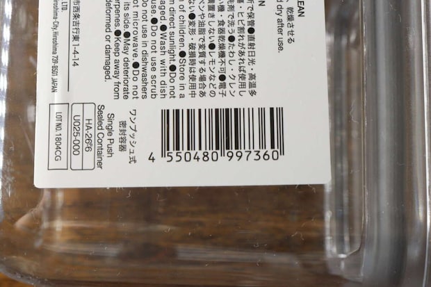 透明な密閉容器の底面に貼られたJANコードと商品情報の一部をクローズアップ 透明な密閉容器の底面に貼られたJANコードと商品情報の一部をクローズアップ