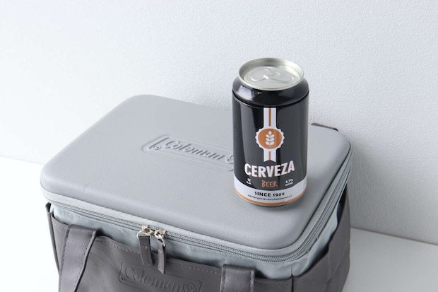 グレーの保冷バッグの蓋の上に黒い缶ビールが置かれている グレーの保冷バッグの蓋の上に黒い缶ビールが置かれている