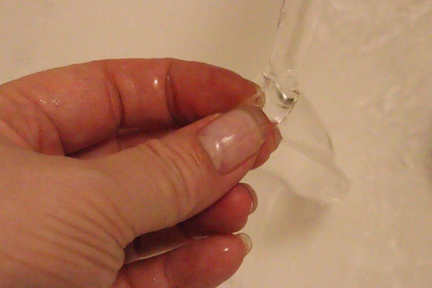 指で持った強力両面粘着ゲルテープを水で洗い流している様子 指で持った強力両面粘着ゲルテープを水で洗い流している様子