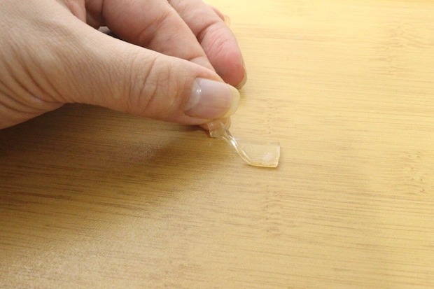 指で木目調トレーからゲルテープを剥がしている様子 指で木目調トレーからゲルテープを剥がしている様子