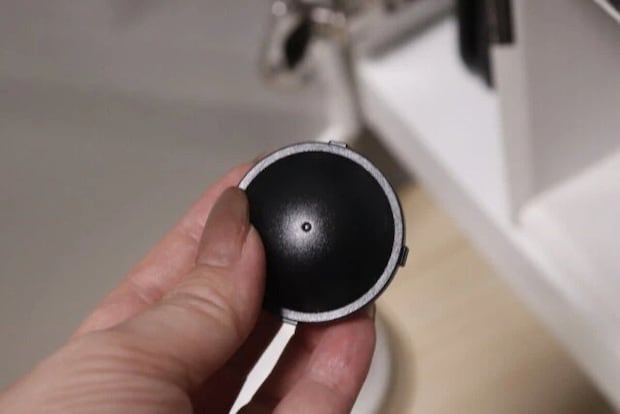 女性の手がゴキブリダンゴの黒い容器を持つ 女性の手がゴキブリダンゴの黒い容器を持つ