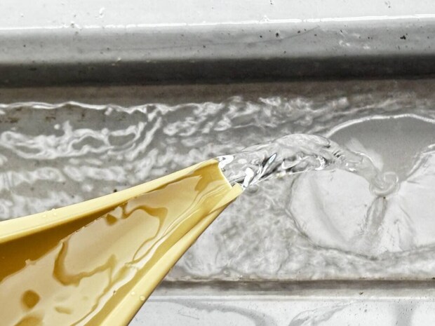 ダイソー水差しバケツのノズルから勢いよく水が注がれている様子