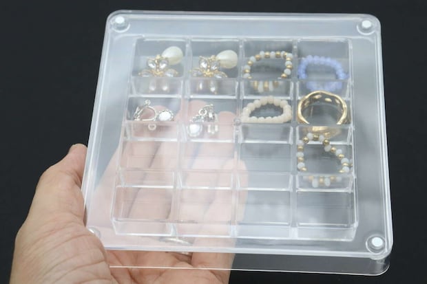 アクセサリーが収納されたディスプレイBOXを手に持っている