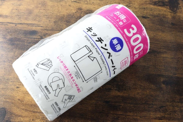 木目調のテーブルに置かれたダイソー単層キッチンペーパーのパッケージ