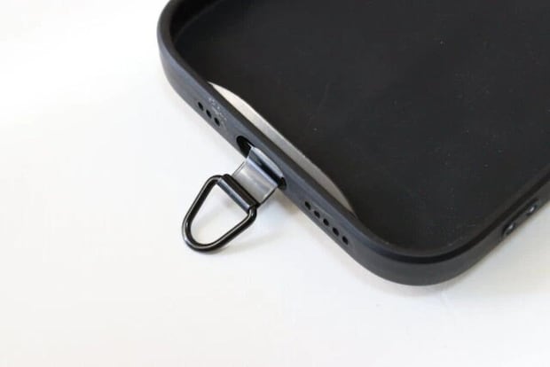 黒いスマホケースの充電口に装着されたストラップホルダー 黒いスマホケースの充電口に装着されたストラップホルダー