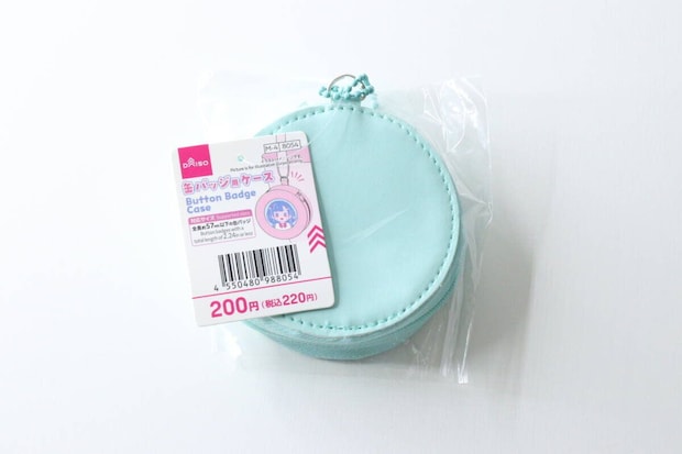 透明な袋に入った水色の缶バッジケースと商品タグ