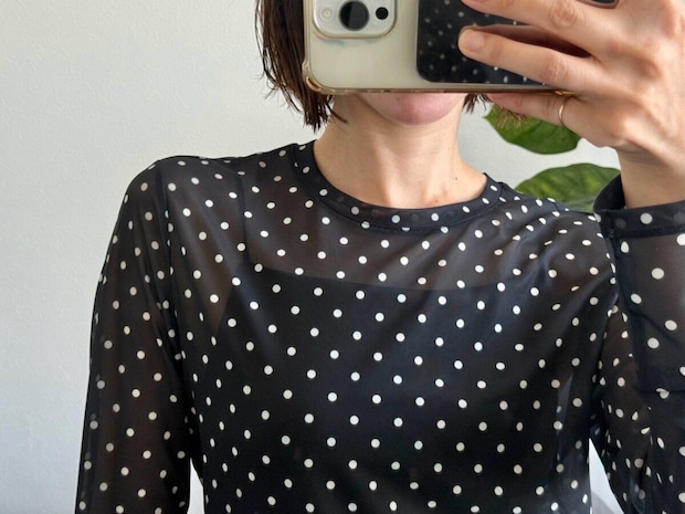 黒ドット柄シアーTを着た女性の上半身アップ
