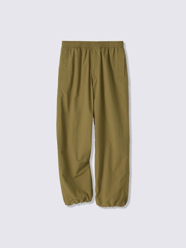カーキ色のナイロンユーティリティパンツが平置きされている