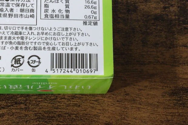 緑色のパッケージの「いわしオイル漬け」缶詰の裏面にあるバーコードと栄養成分表示の一部