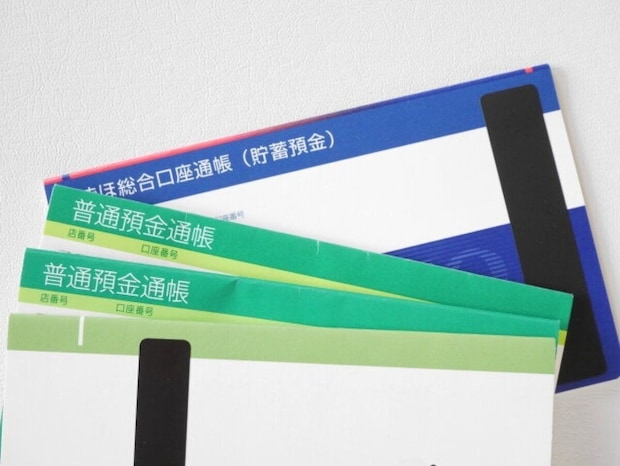 緑と青の普通預金通帳と総合口座通帳が重なっている