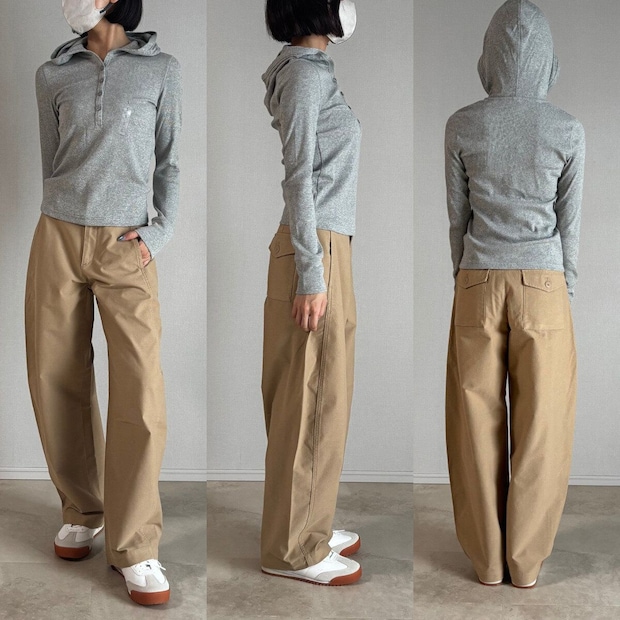 グレーのフーデッドリブTとベージュパンツを着用した女性の全身