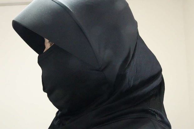 黒いフェイスガードを着用した人物の横顔。目元だけが見えており、顔全体が覆われている