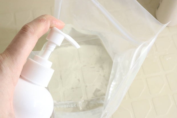 ポンプ式の洗剤を「つけ置き洗いバッグ」に入れている手元