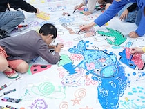 【沖縄県南城市】南都グループ周年プロモーション第1弾、子ども63名が大空を描く巨大アート制作