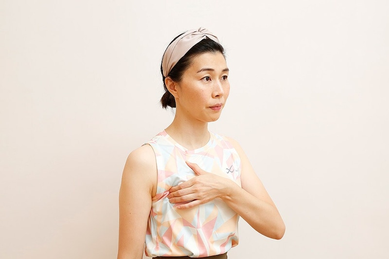 左手でデコルテの右端をぎゅっとつまむ。つまみにくい場合は、少し背中を丸めてつまむ。