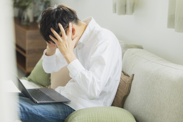 　男性　頭を抱える　自宅　叫ぶ