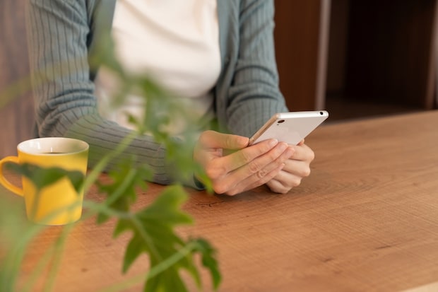 スマホ　夜　女性　リビング　手元