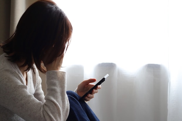 女性　スマホ　暗い　悲しい