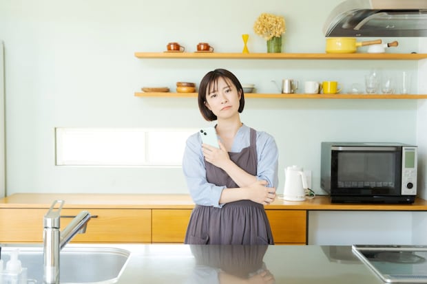 イライラ　スマホ　女性　キッチン
