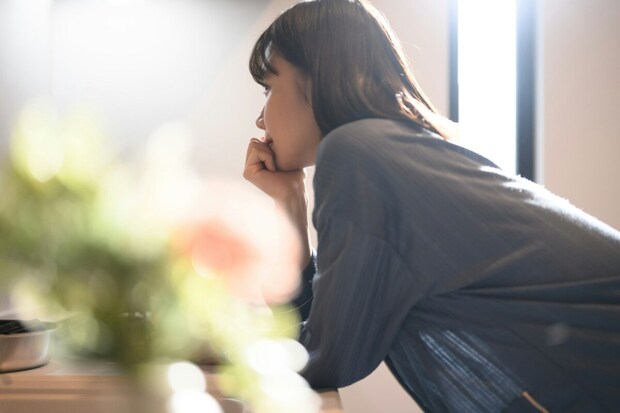 女性　　窓　暗い　家